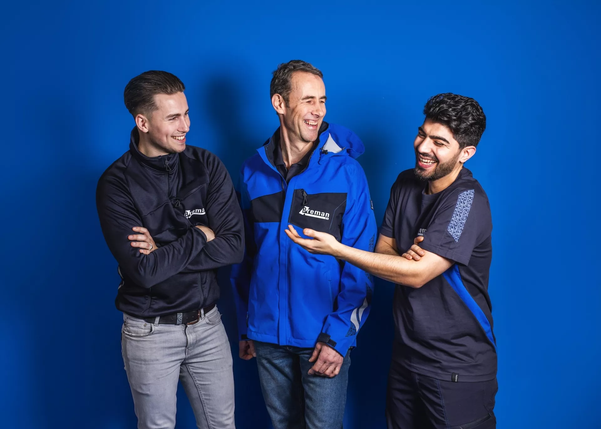 Drie lachende installateurs van Breman Installatiegroep