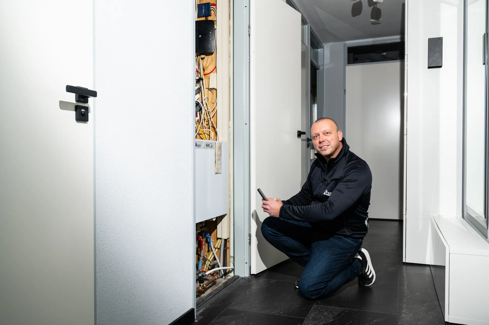 Een technicus maakt een opname van een installatie in een moderne gang.