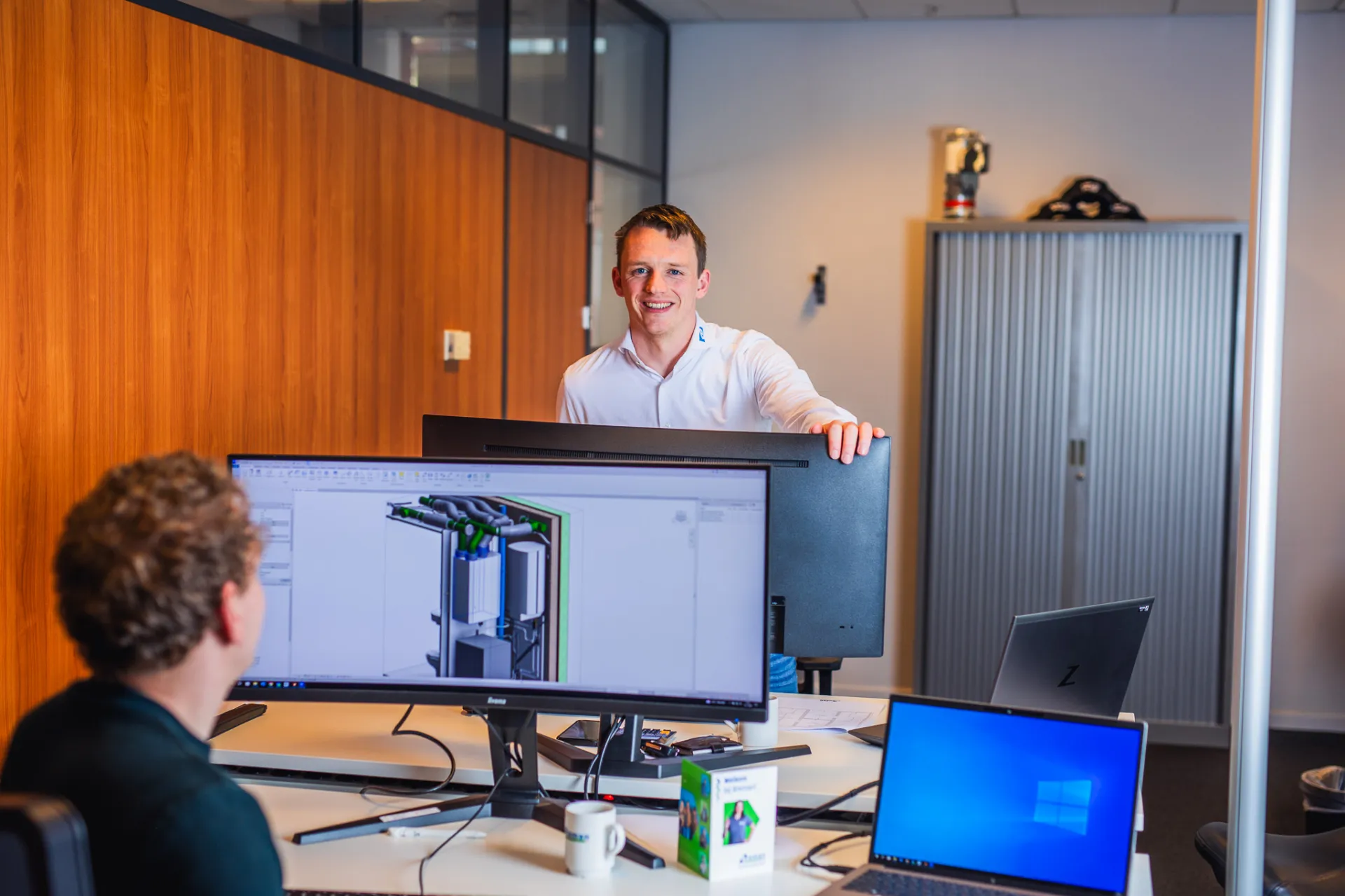 Kantooromgeving van collega's die met BIM werken op een computerscherm.