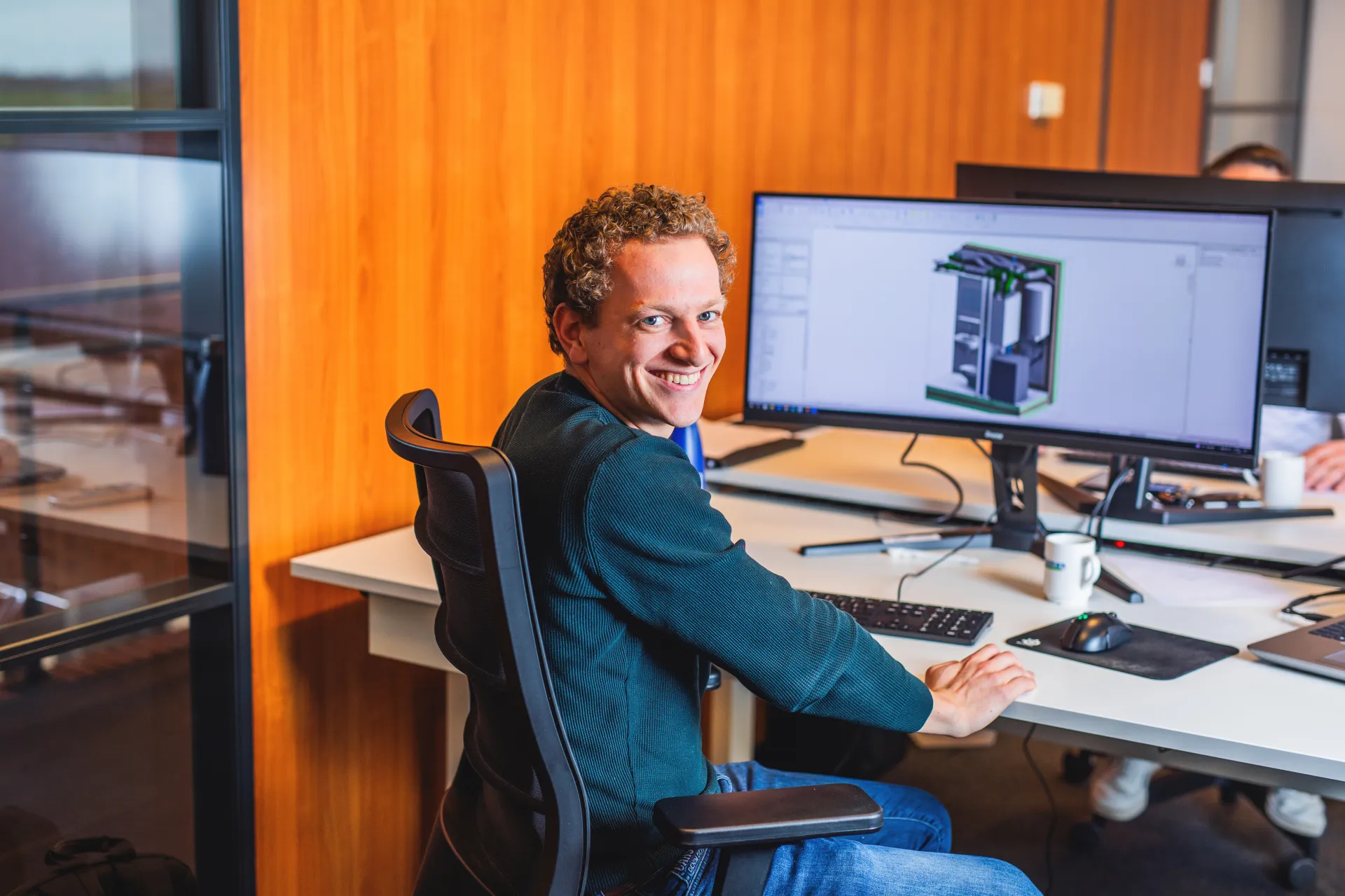 Breman-collega werkt aan een computer met een technisch ontwerp op het scherm.