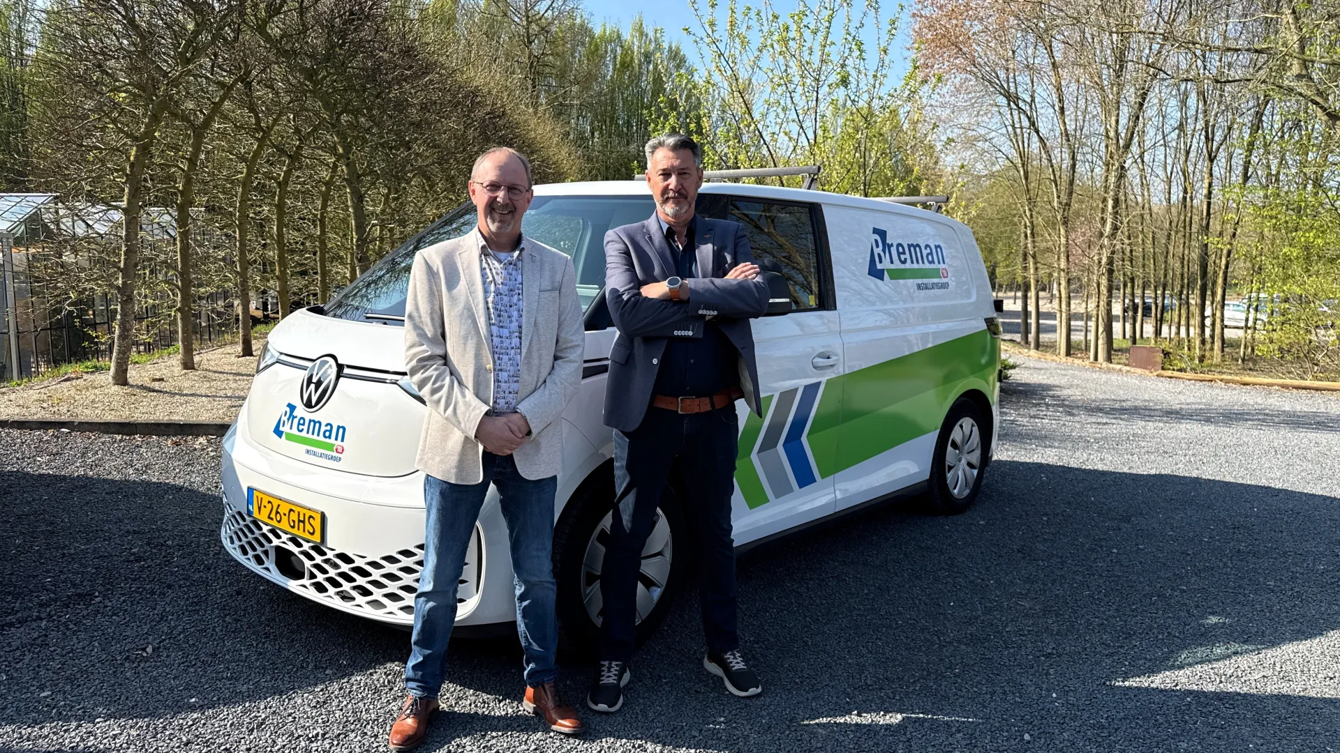 Twee mannen poseren voor een Breman bus.