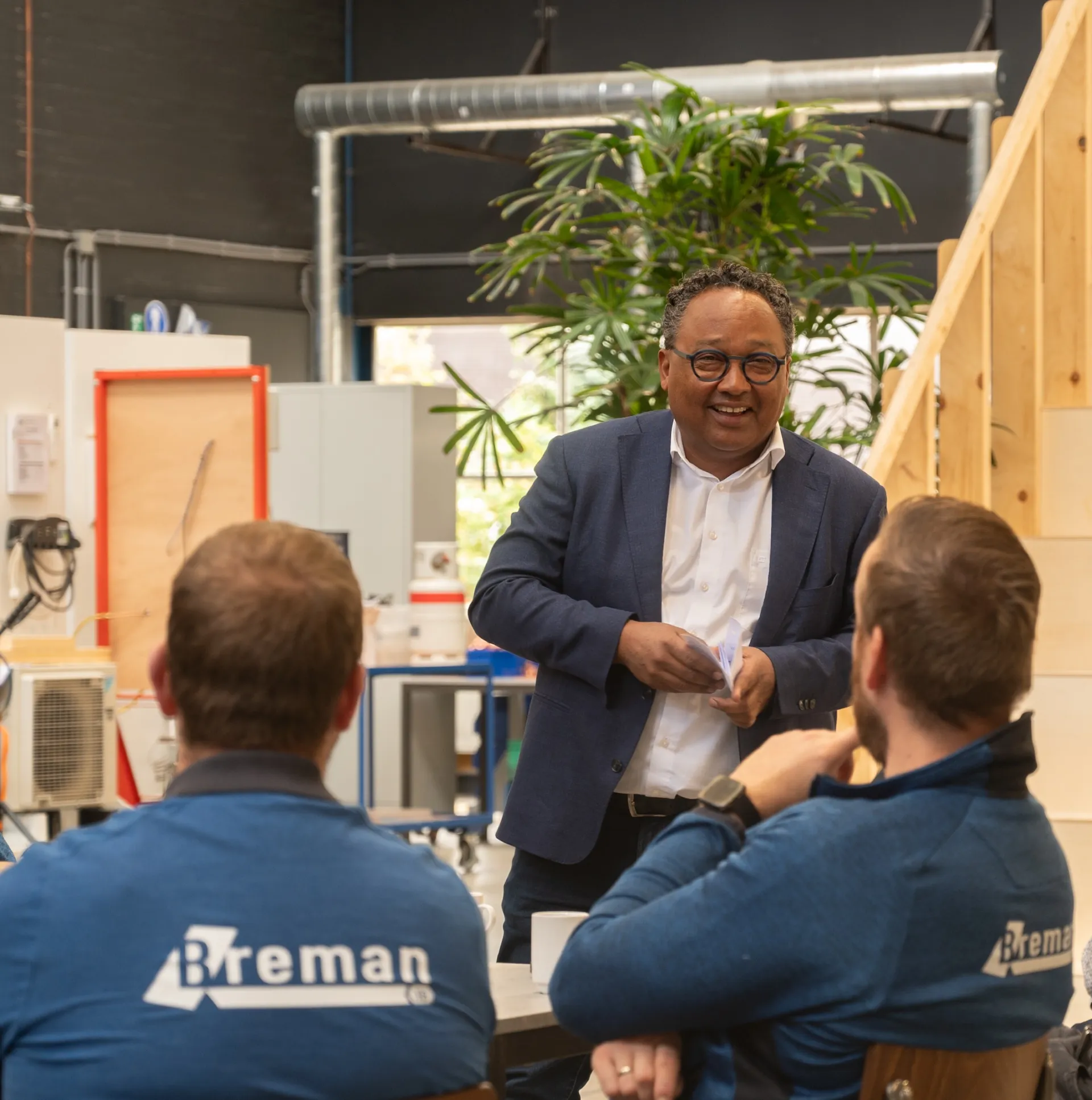Manager van de Breman Academy staat voor een groep collega's