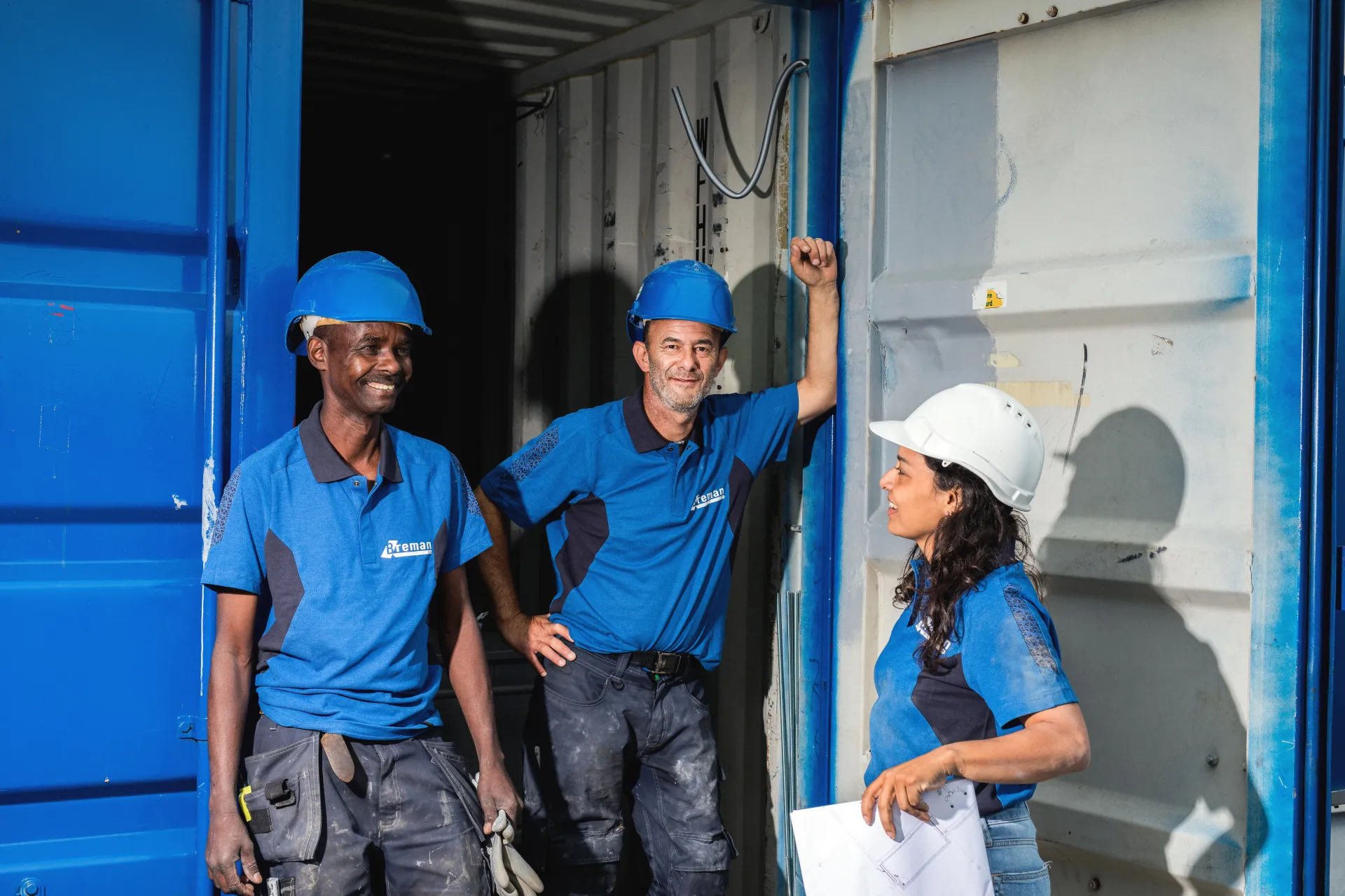 Collega's op de bouw in gesprek bij een container.