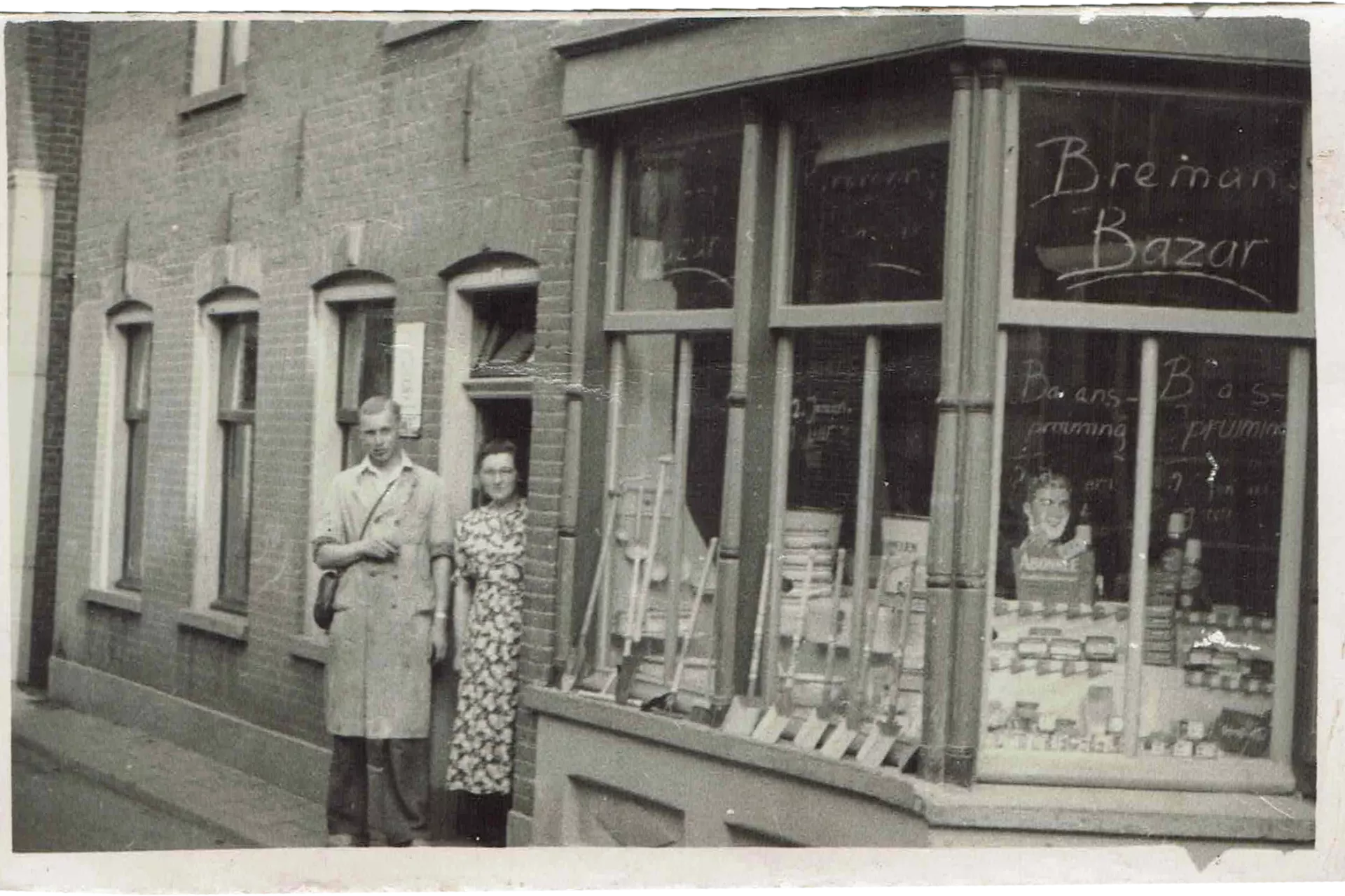 Winkelpui met raamtekst “Breman Bazar” en twee personen bij de ingang