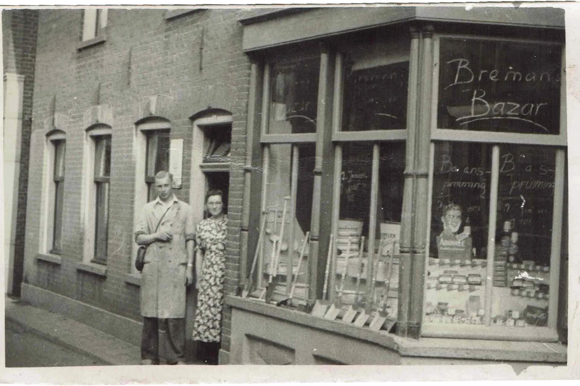 Winkelpui met raamtekst “Breman Bazar” en twee personen bij de ingang