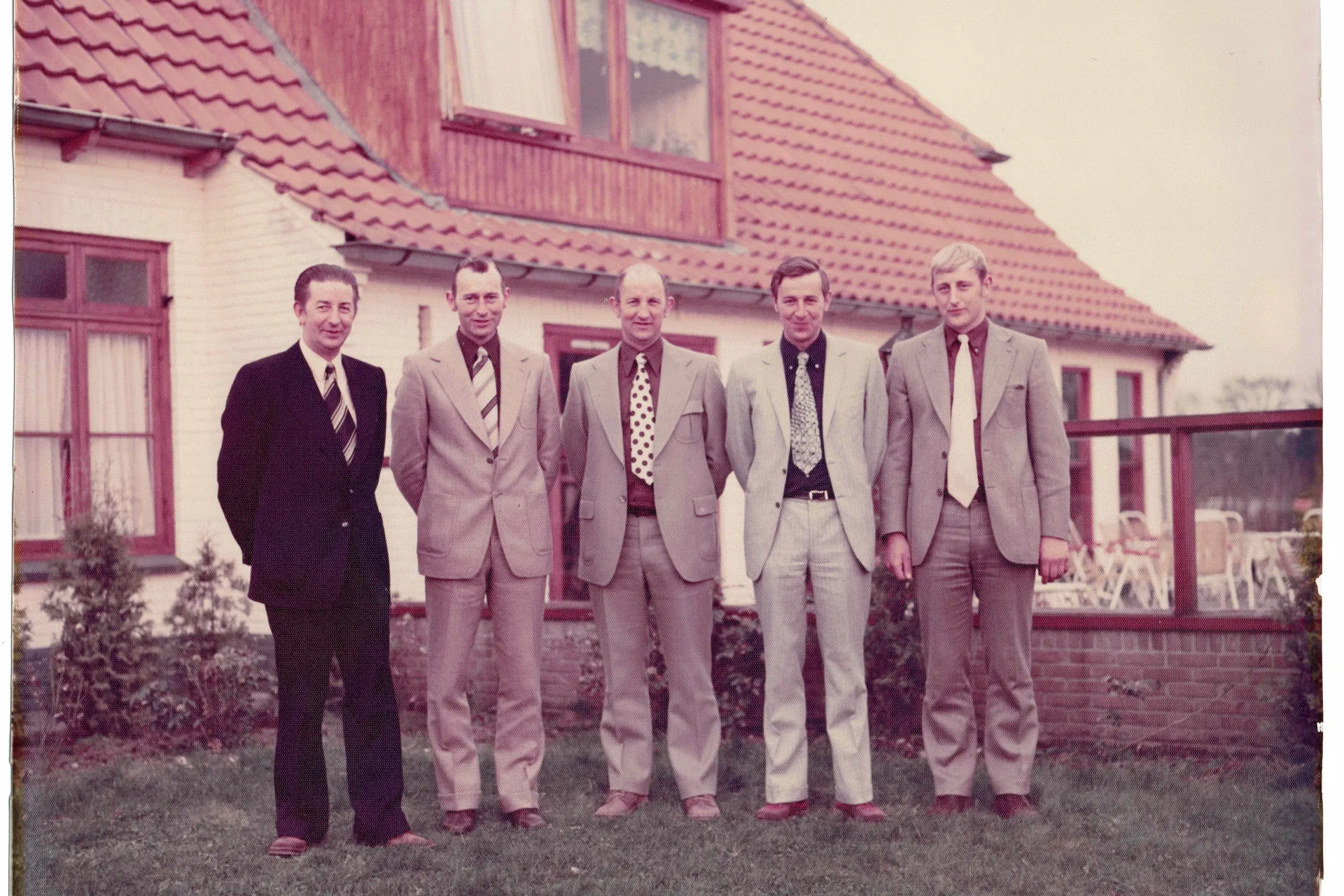 Vijf zonen van Breman poseren buiten voor een woning (historische foto)
